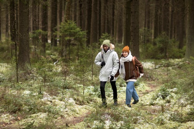 Hombre y mujer joven en un bosque juntos durante un viaje por carretera de invierno