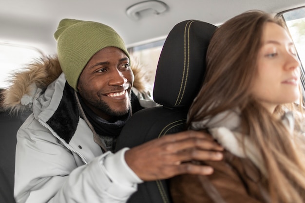 Hombre y mujer joven en el coche listos para un viaje por carretera de invierno juntos