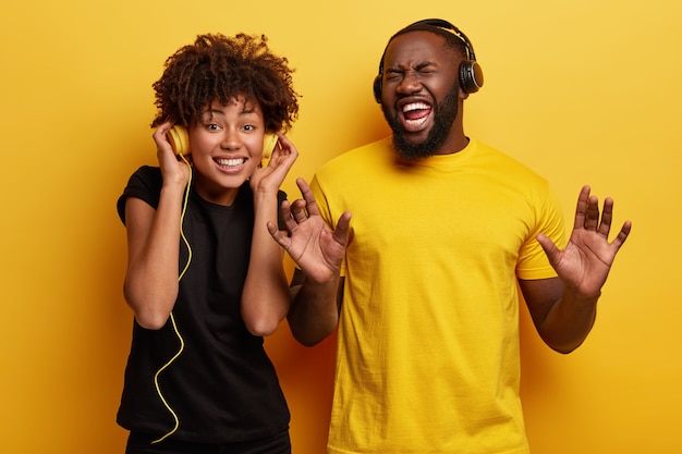 Hombre y mujer joven escuchando música en auriculares