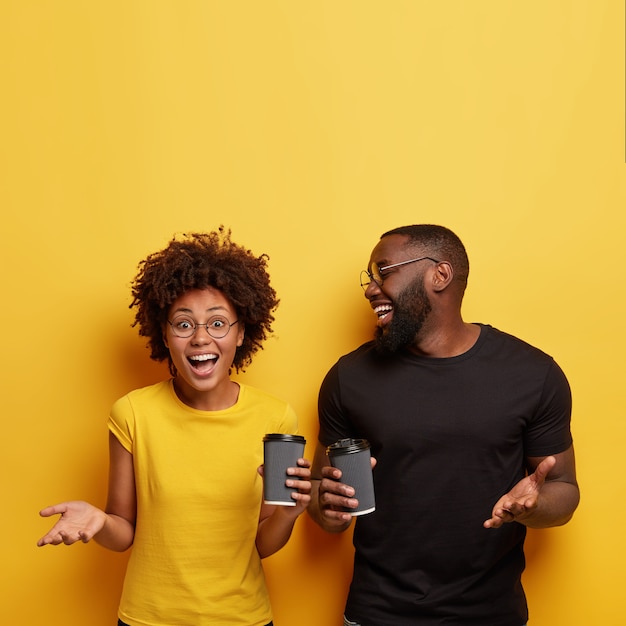 Hombre y mujer joven sosteniendo tazas de café