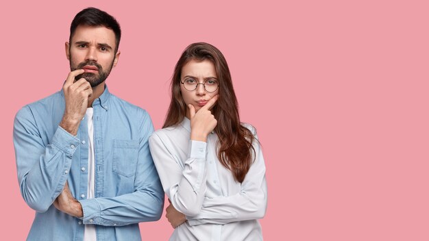 Hombre y mujer jóvenes con camisas posando