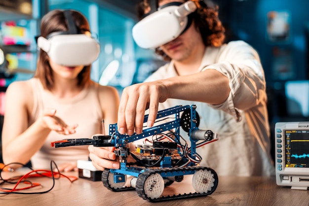 Foto gratuita hombre y mujer jóvenes con gafas vr haciendo experimentos en robótica en un laboratorio robot y herramientas