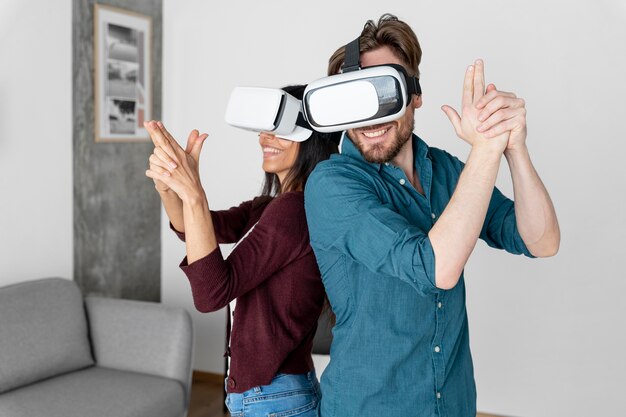 Hombre y mujer juegan juntos con casco de realidad virtual en casa