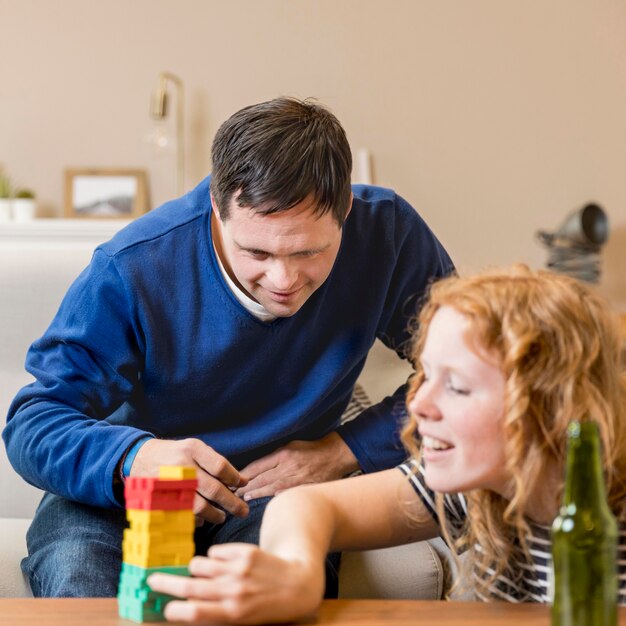 Hombre y mujer jugando en casa tomando cerveza