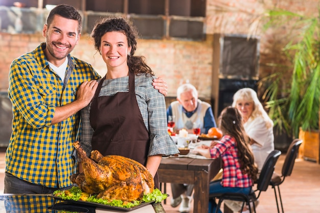 Foto gratuita hombre y mujer junto a bandeja con jamón asado