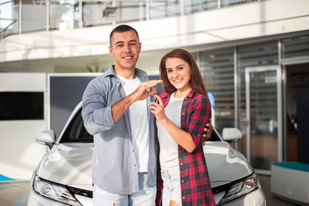 Hombre y mujer juntos en concesionario de automóviles