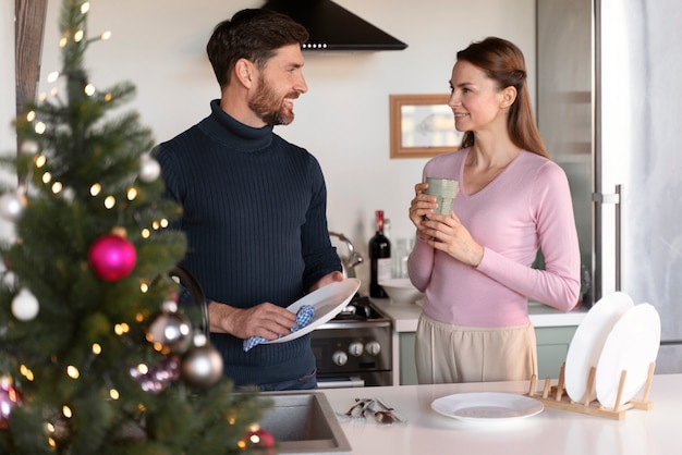 Hombre y mujer lavando los platos juntos en navidad