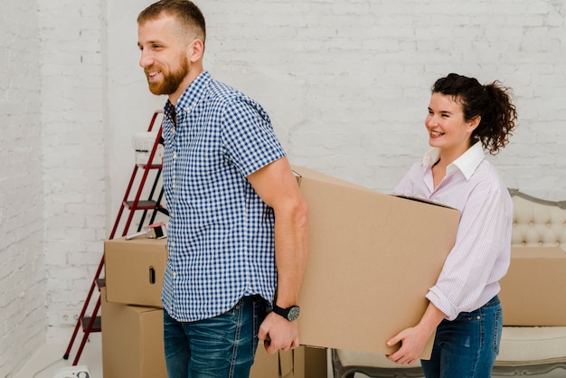 Foto gratuita hombre y mujer llevando caja