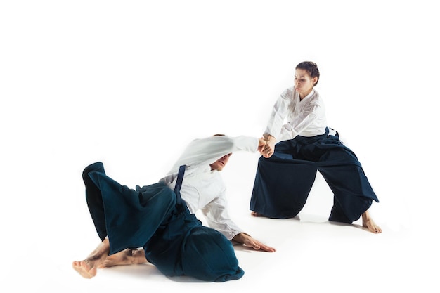 Foto gratuita hombre y mujer luchando y entrenando aikido en la pared blanca del estudio