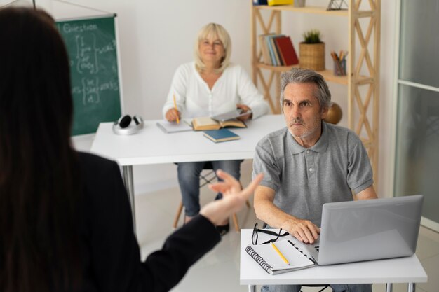 Hombre y mujer mayores prestando atención en clase
