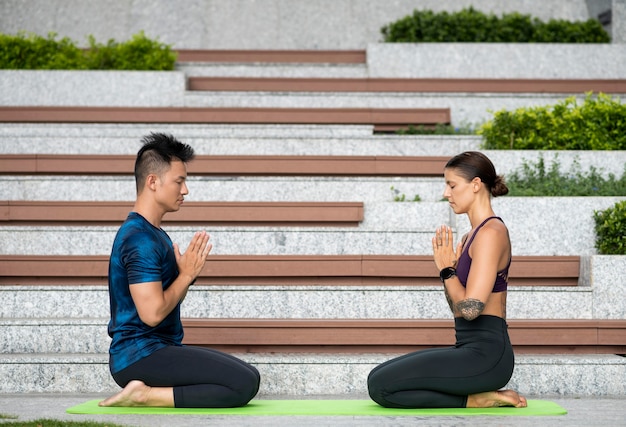 Hombre y mujer meditando mientras hace yoga