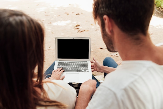 Hombre y mujer mirando una computadora portátil