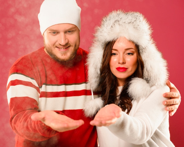 Foto gratuita hombre y mujer modelos de navidad mirando las manos