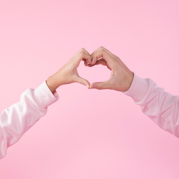 Hombre y mujer mostrando el símbolo del corazón