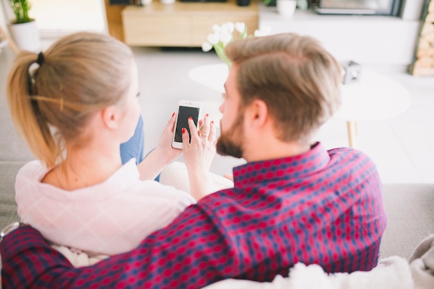 Hombre y mujer navegando smartphone juntos