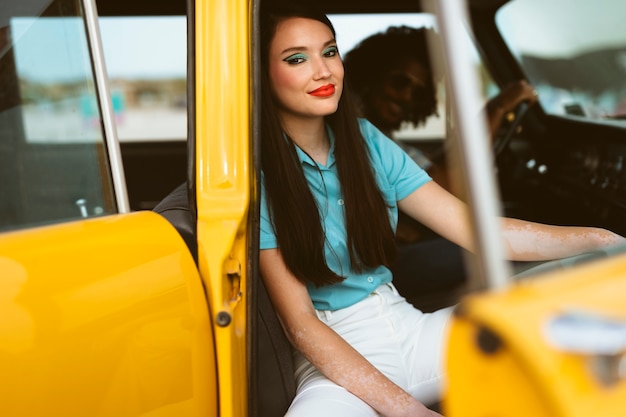 Hombre y mujer posando en estilo retro con coche.