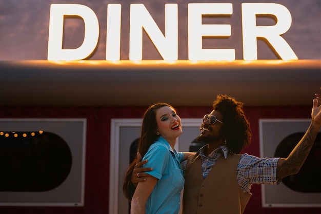 Hombre y mujer posando en estilo retro fuera del restaurante