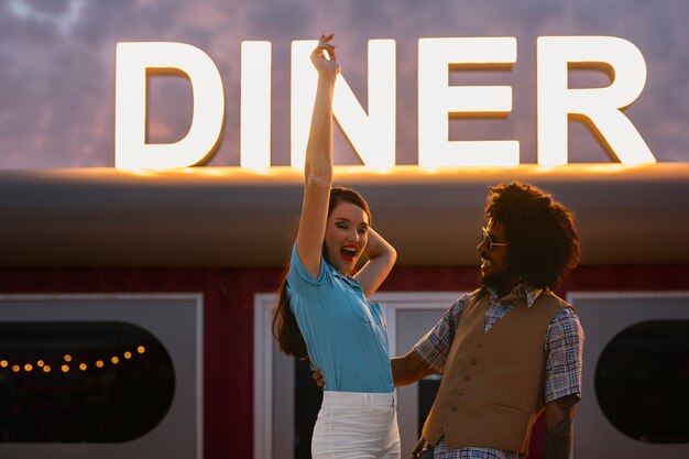 Hombre y mujer posando en estilo retro fuera del restaurante