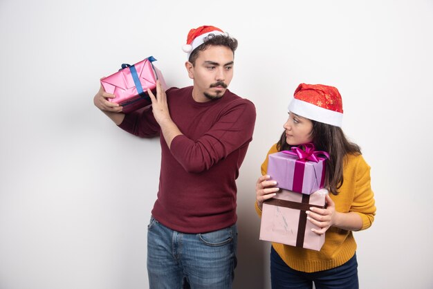 Hombre y mujer posando con regalos de Navidad.