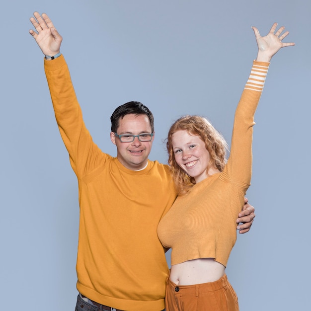 Foto gratuita hombre y mujer posando con su mano arriba