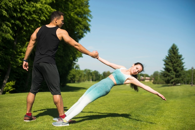 Foto gratuita hombre y mujer practicando yoga al aire libre