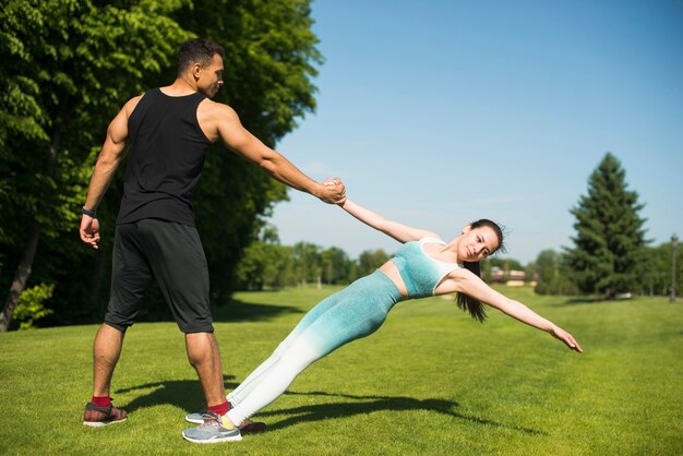 Hombre y mujer practicando yoga al aire libre