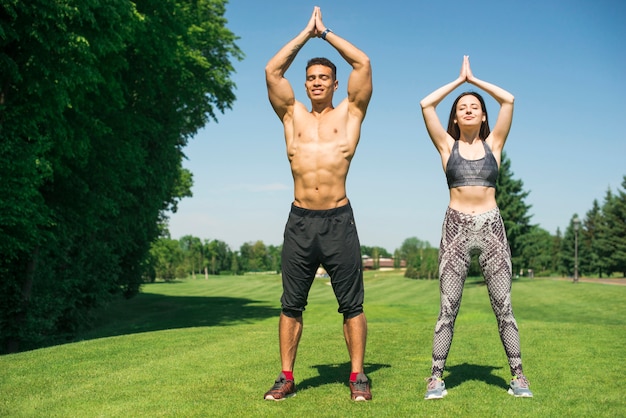 Hombre y mujer practicando yoga al aire libre