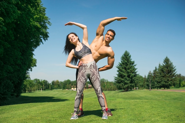 Hombre y mujer practicando yoga al aire libre