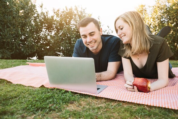 Hombre y mujer que usa la computadora portátil en comida campestre