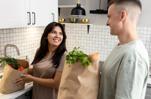 Hombre y mujer recibiendo bolsas de papel después de las compras en línea