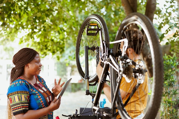 Foto gratuita hombre y mujer reparando bicicletas al aire libre