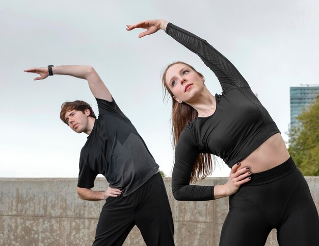 Hombre y mujer en ropa deportiva haciendo ejercicio al aire libre