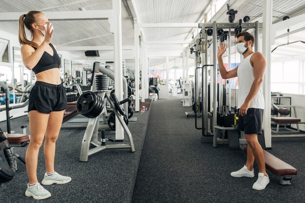 Hombre y mujer saludando el uno al otro en el gimnasio