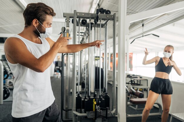 Hombre y mujer saludándose en el gimnasio