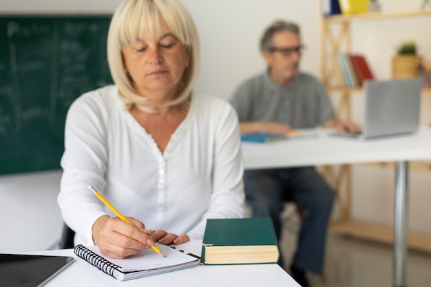 Hombre y mujer senior prestando atención en clase