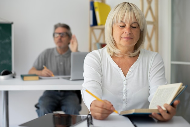 Foto gratuita hombre y mujer senior prestando atención en clase