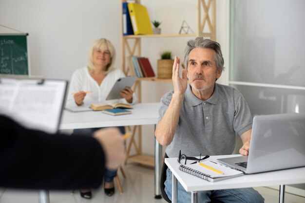 Hombre y mujer senior prestando atención en clase