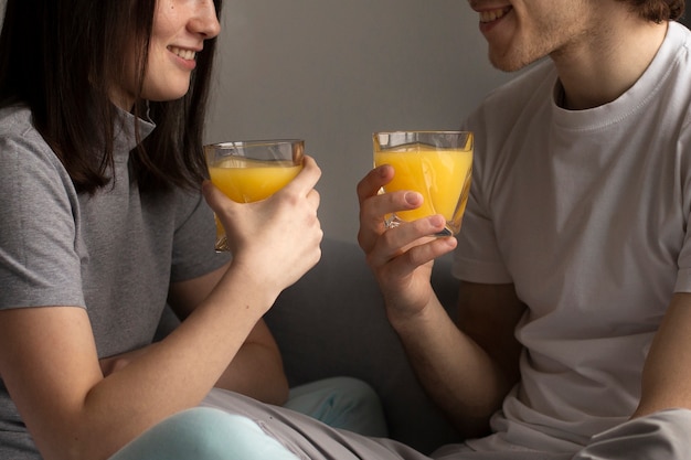 Foto gratuita hombre y mujer sonriendo y sosteniendo jugo de naranja