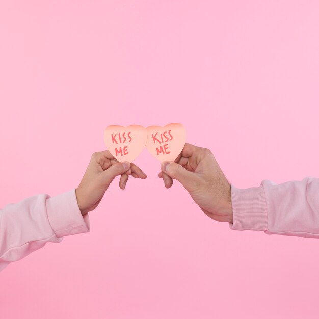 Hombre y mujer sosteniendo símbolos decorativos de papel de corazón