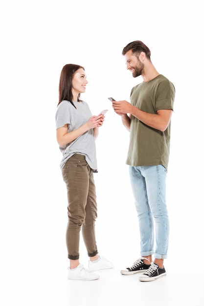 Hombre y mujer con teléfonos inteligentes mirándose