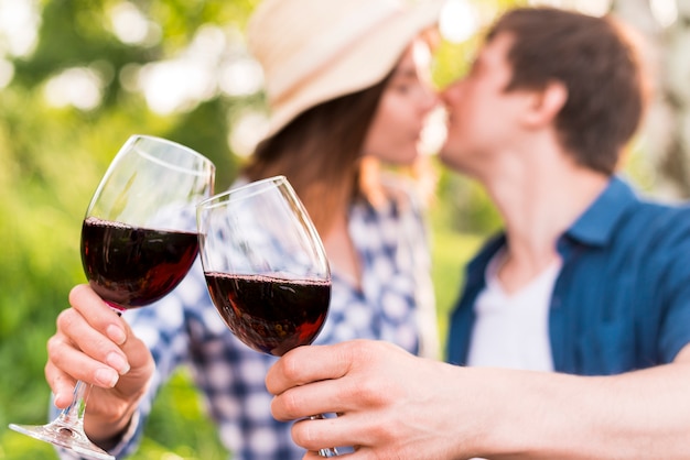 Hombre y mujer tintineando copas con vino