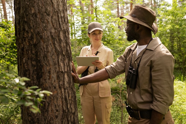 Foto gratuita hombre y mujer de tiro medio en el bosque