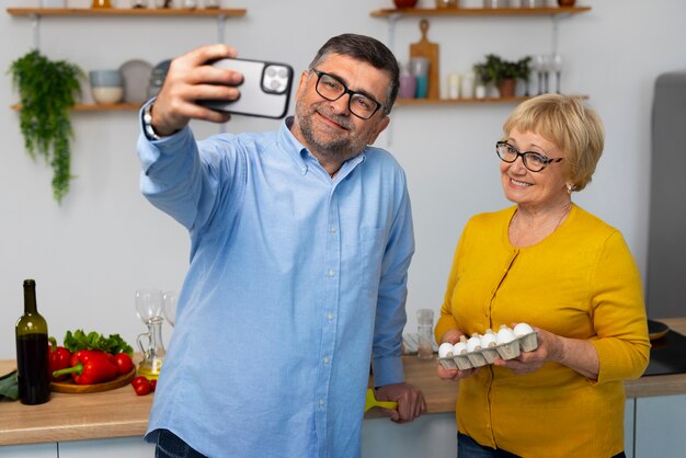 Hombre y mujer de tiro medio cocinando en la cocina