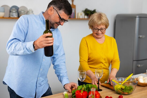 Hombre y mujer de tiro medio cocinando en la cocina