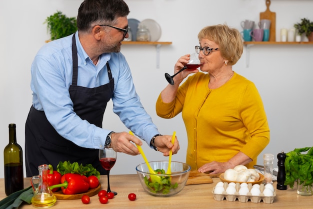 Hombre y mujer de tiro medio cocinando en la cocina