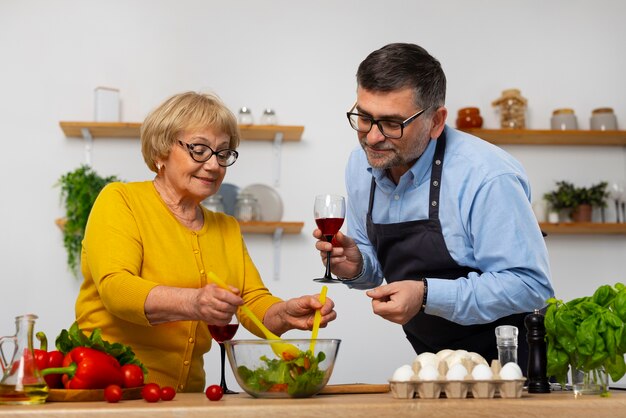 Hombre y mujer de tiro medio cocinando en la cocina