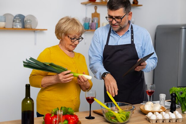 Hombre y mujer de tiro medio cocinando en la cocina