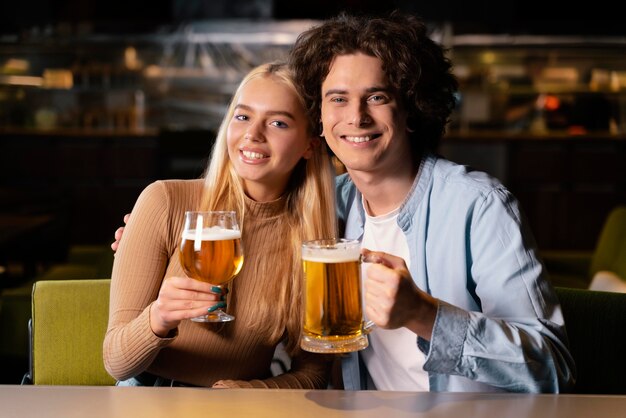 Hombre y mujer de tiro medio en el pub