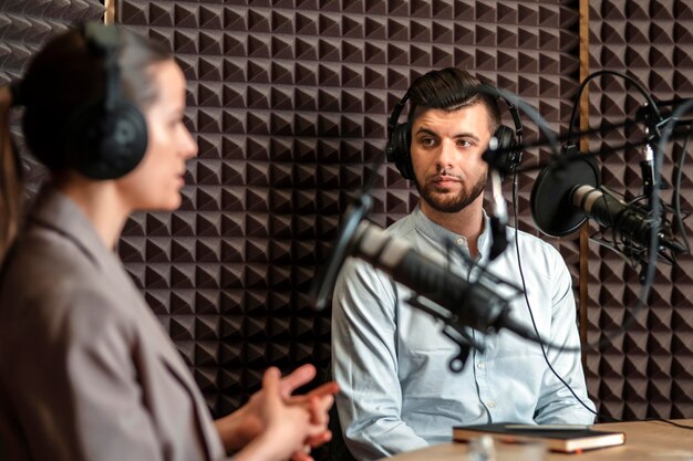 Hombre y mujer de tiro medio en la radio