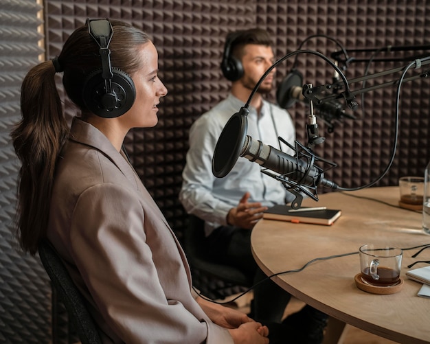 Hombre y mujer de tiro medio en la radio